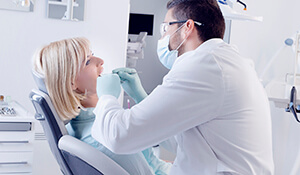 dentist examining female patient's mouth